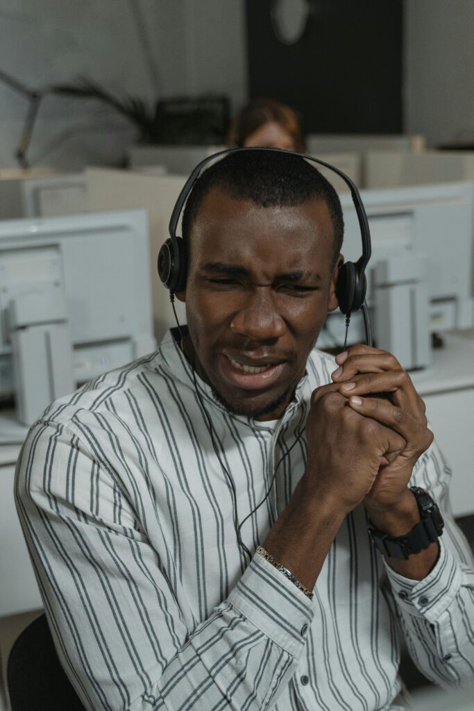 Focused call center agent providing technical support in a busy office.